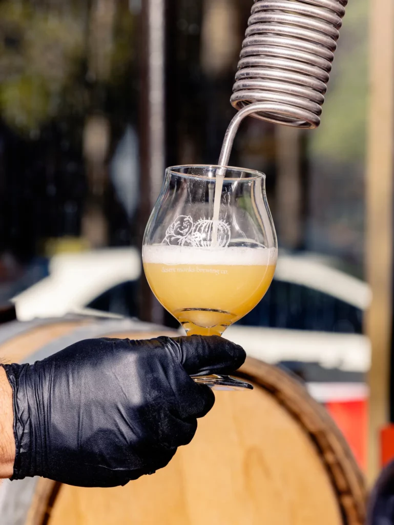 image of beer being poured into a short glass while hand holds glass
