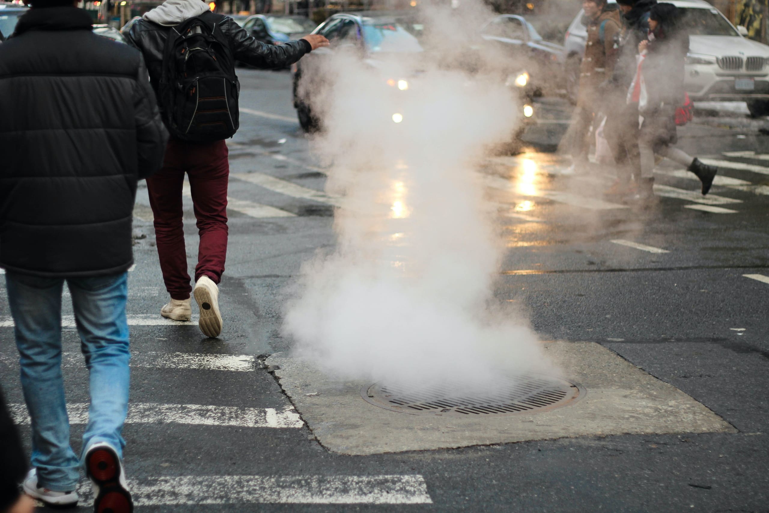 Image of street showing steam escaping from manhole
